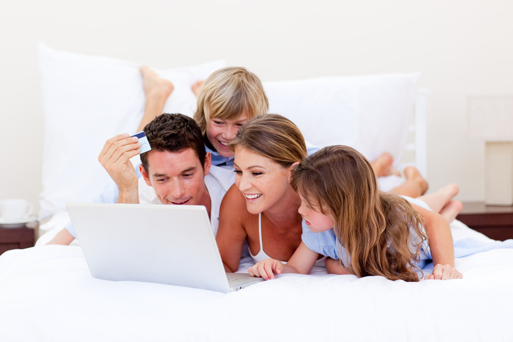 Animated family buying online lying down on bed at home